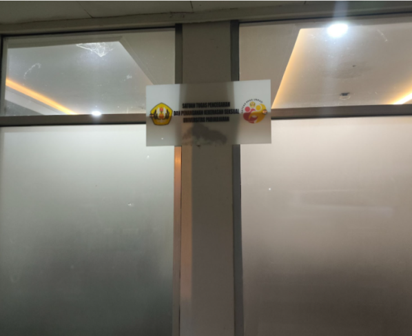 Papan nama Satgas PPKS Unpad tampak terpasang di area depan kantor dengan latar tembok berwarna putih. (WARTA KEMA/Razan Jayaputra Partadinata)